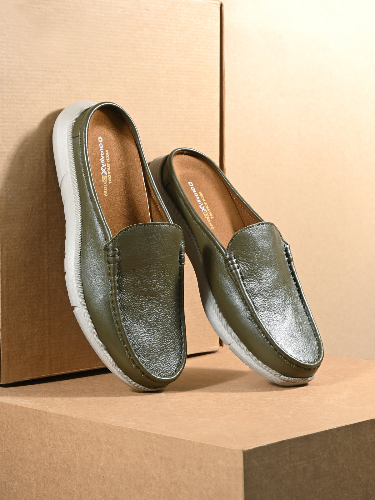 Green loafers on a beige background