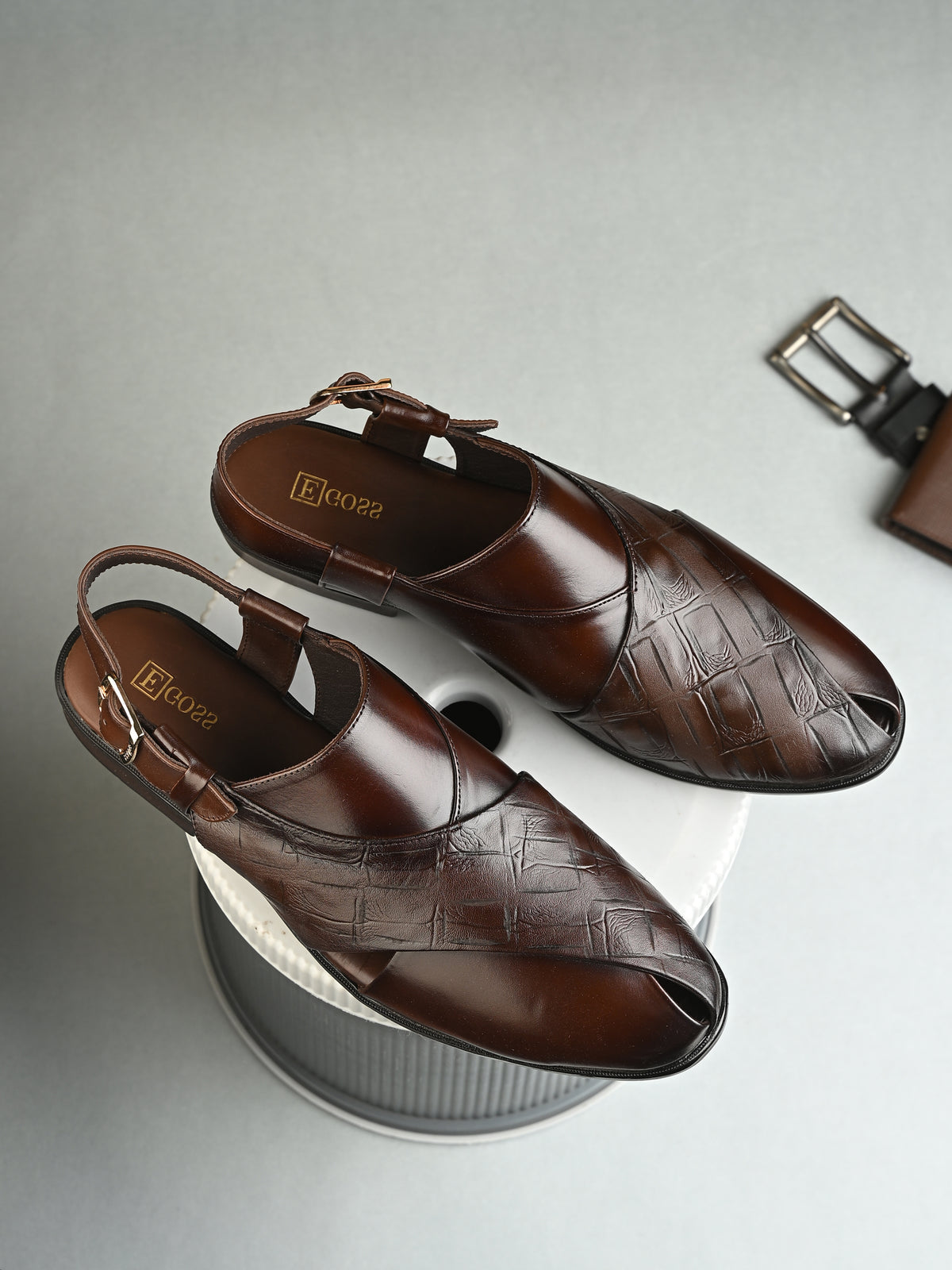 Brown leather shoes with 'BOSS' branding on a light gray background
