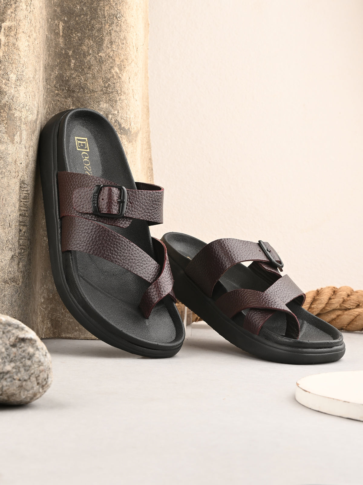 Brown sandals with a buckle design on a neutral background