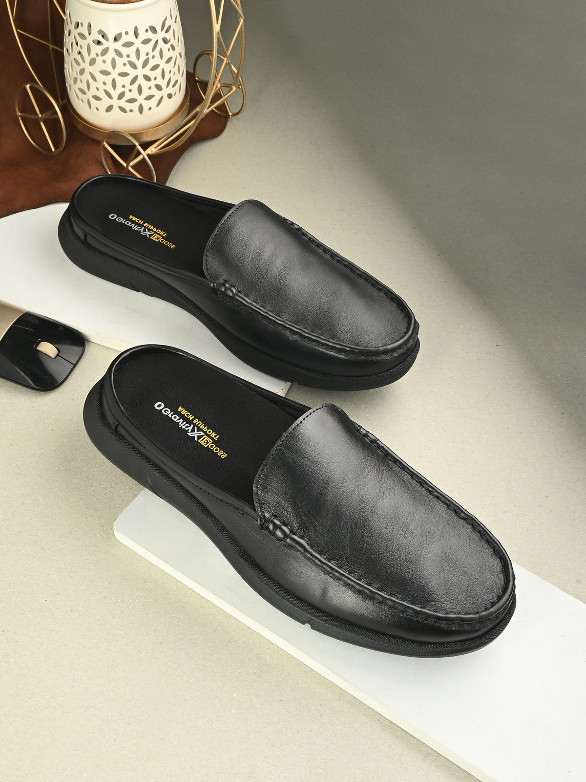 Pair of black loafers on a white surface.