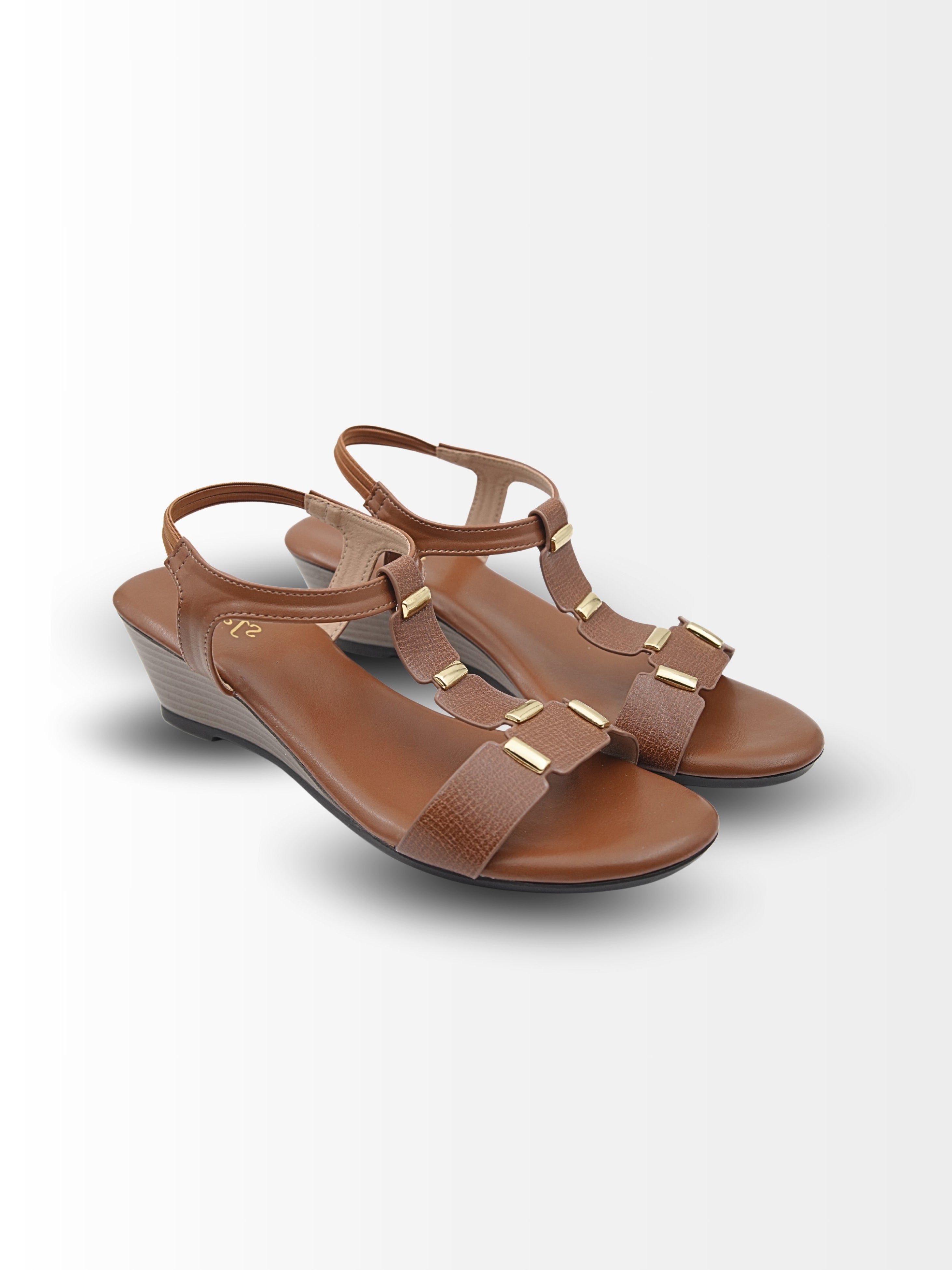 Pair of brown sandals with gold accents on a light gray background