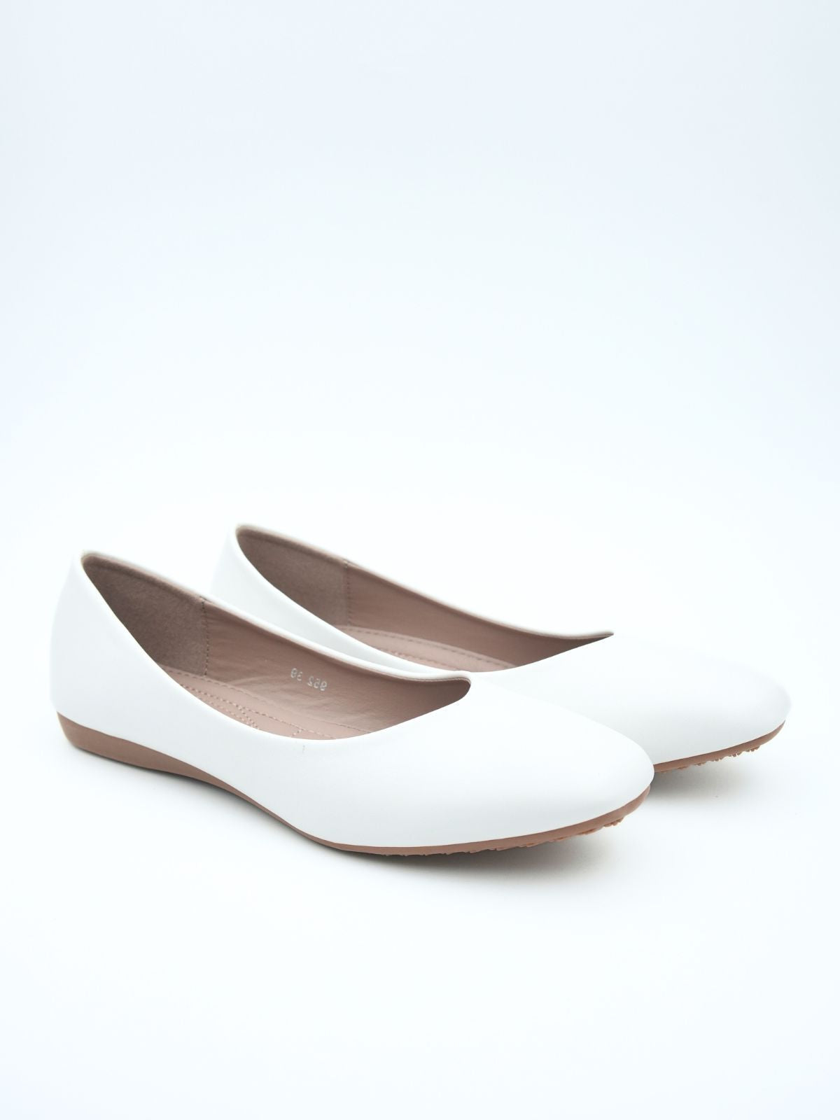 Pair of white flat shoes on a light beige background