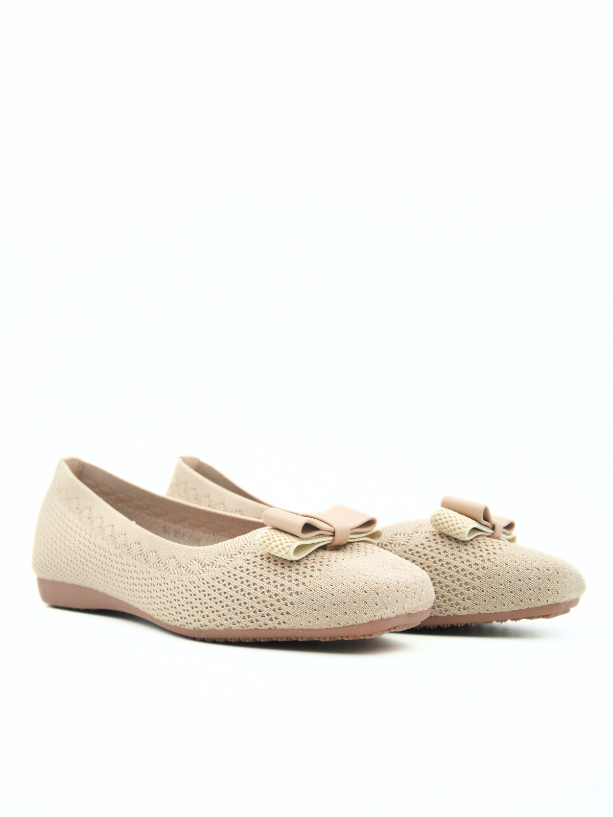 Pair of beige knitted flats with bow details on a white background