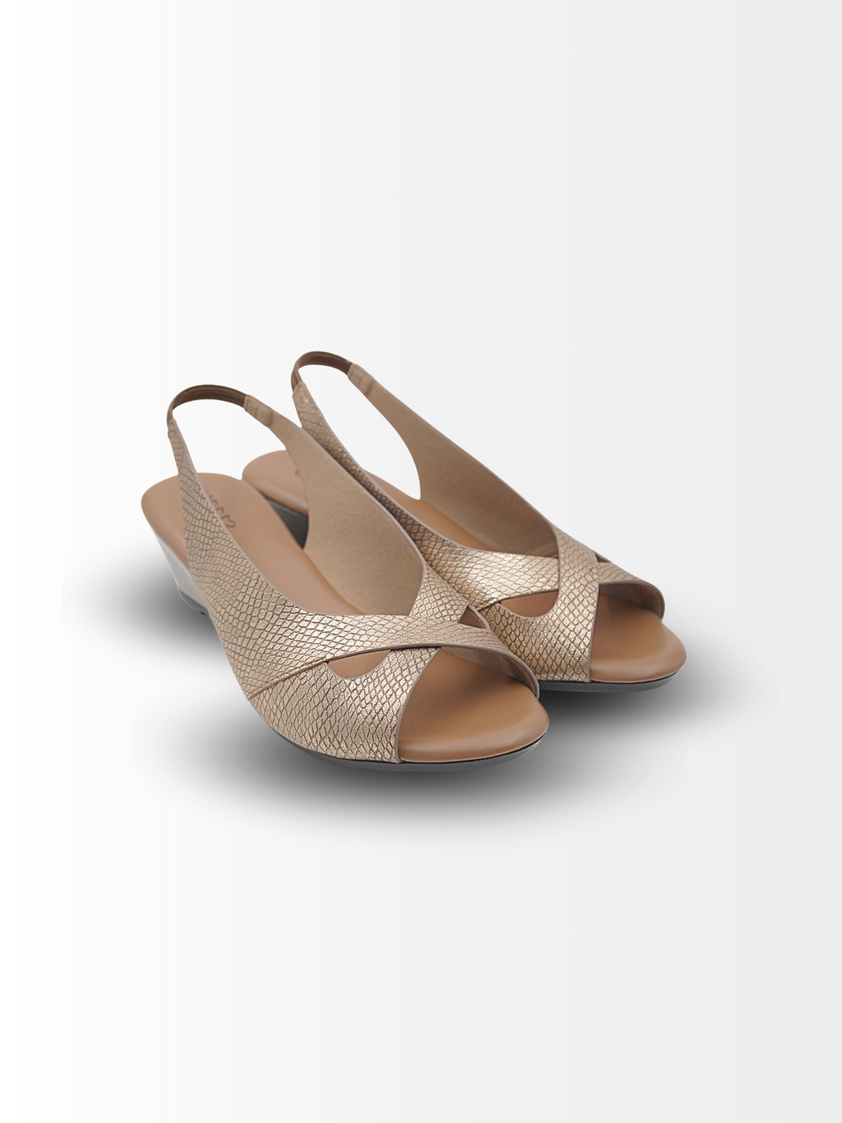 Pair of gold and beige open-toe shoes on a white background